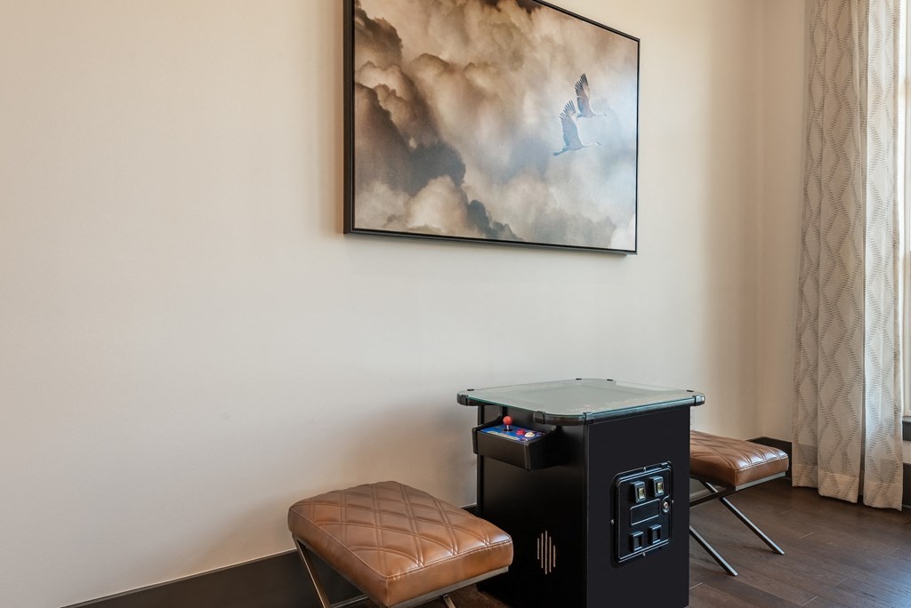 a game room with a table and chairs and a painting on the wall