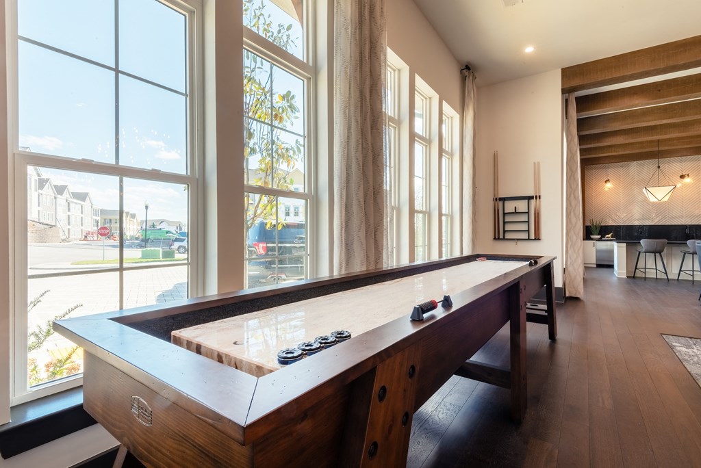 a pool table in a living room with large windows