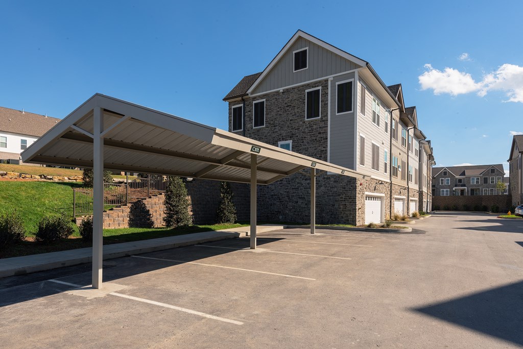 an empty parking lot with an apartment building in the background