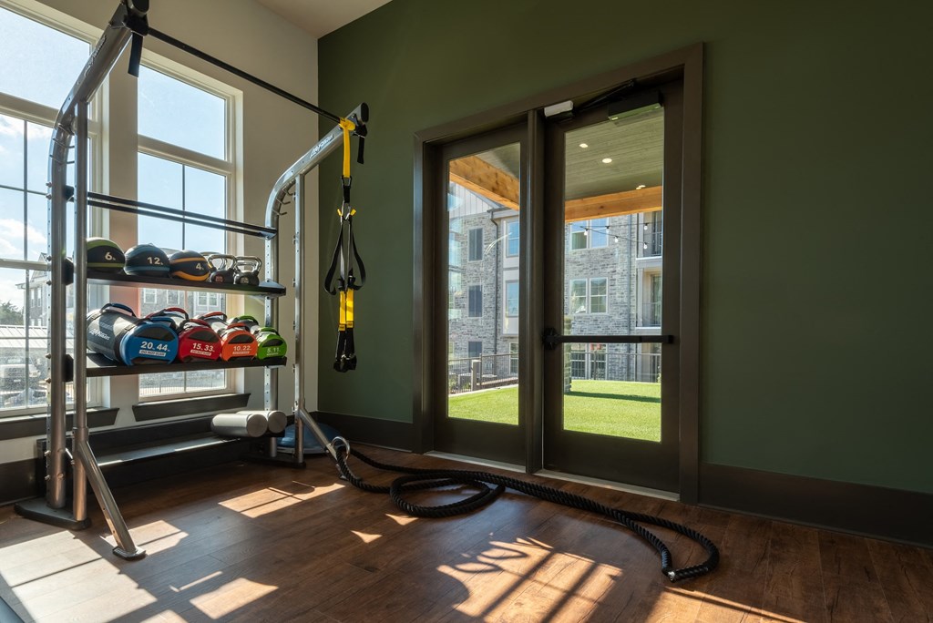 a home gym with a view of the yard and a glass door