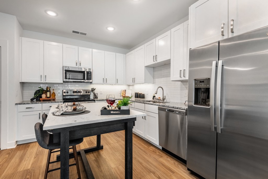 a kitchen with stainless steel appliances and a marble counter top