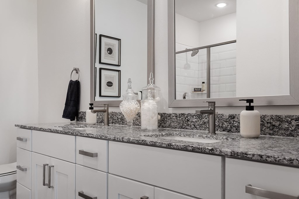 an example of a bathroom with a granite counter top and a sink and a mirror