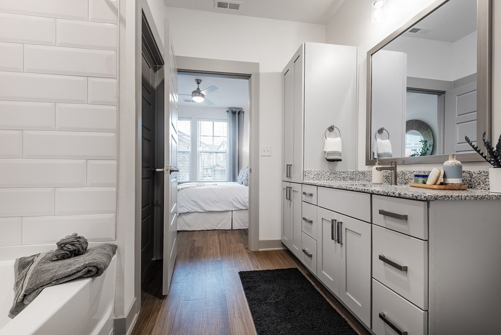 a bathroom with white cabinets and a sink and a mirror