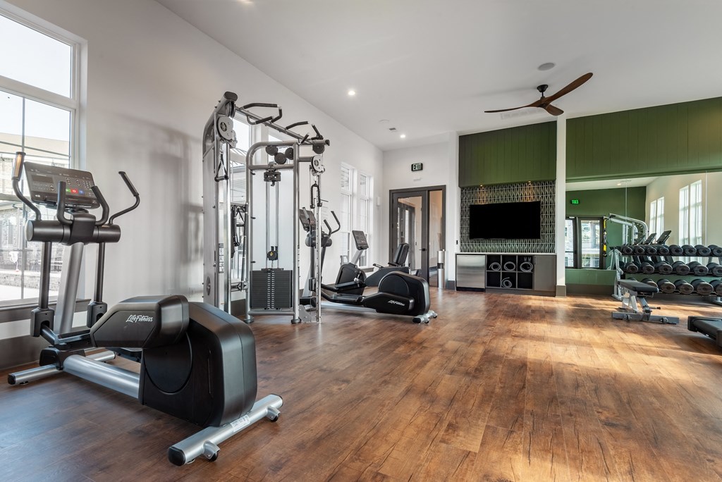 a gym with weights and other exercise equipment and a tv
