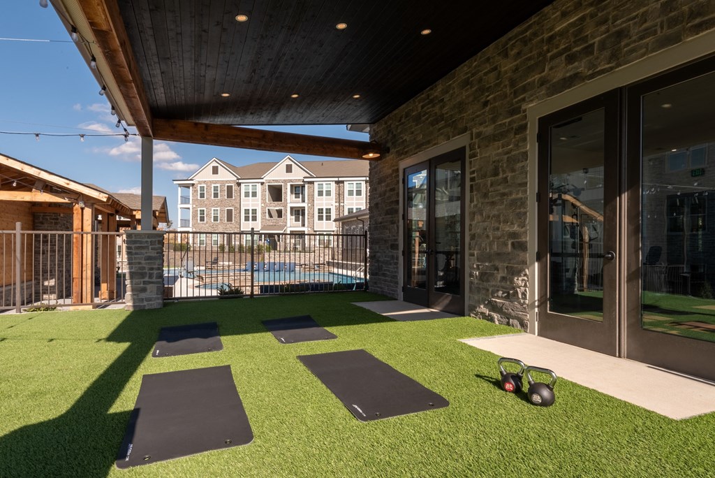 the yard of a home with yoga mats and a pool