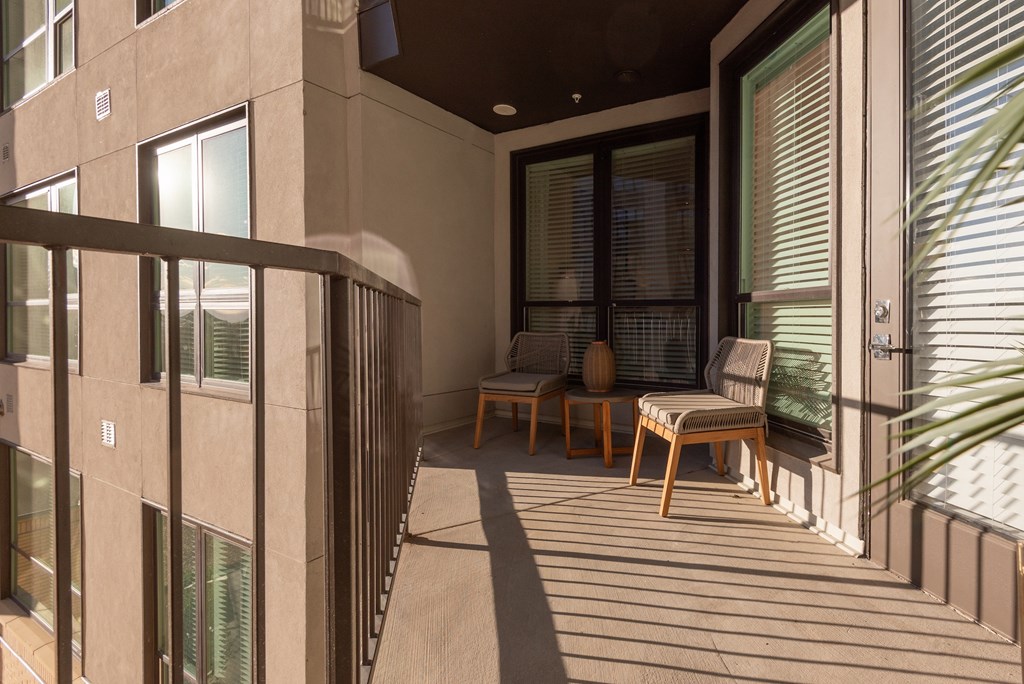 A balcony with a table and chairs is shown.