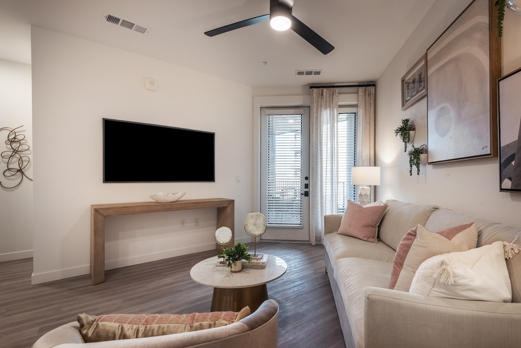 A living room with a couch, a coffee table, and a television.