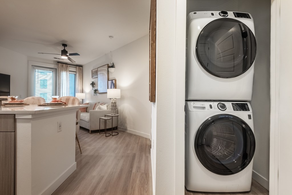 A white washing machine is in a small laundry room.