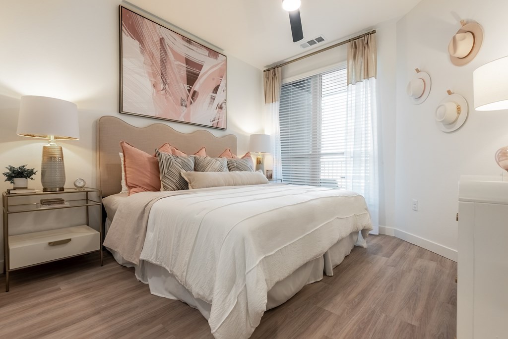 A bedroom with a large bed and a painting above it.