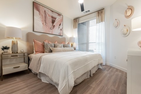 A bedroom with a large bed and a painting above it.