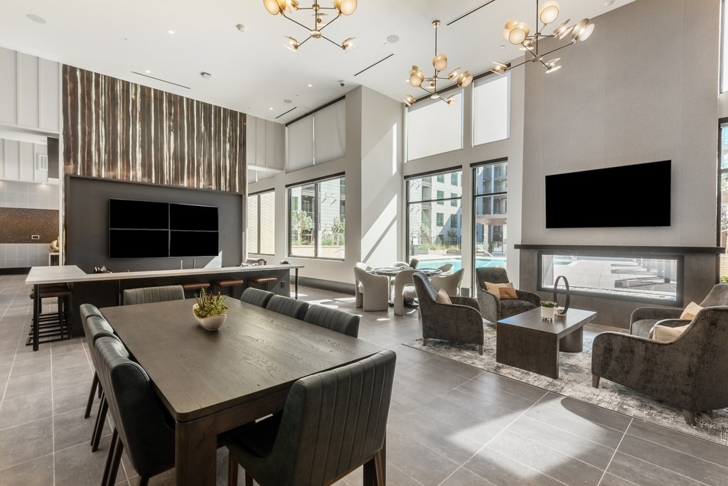A modern living room with a wooden dining table and black chairs.