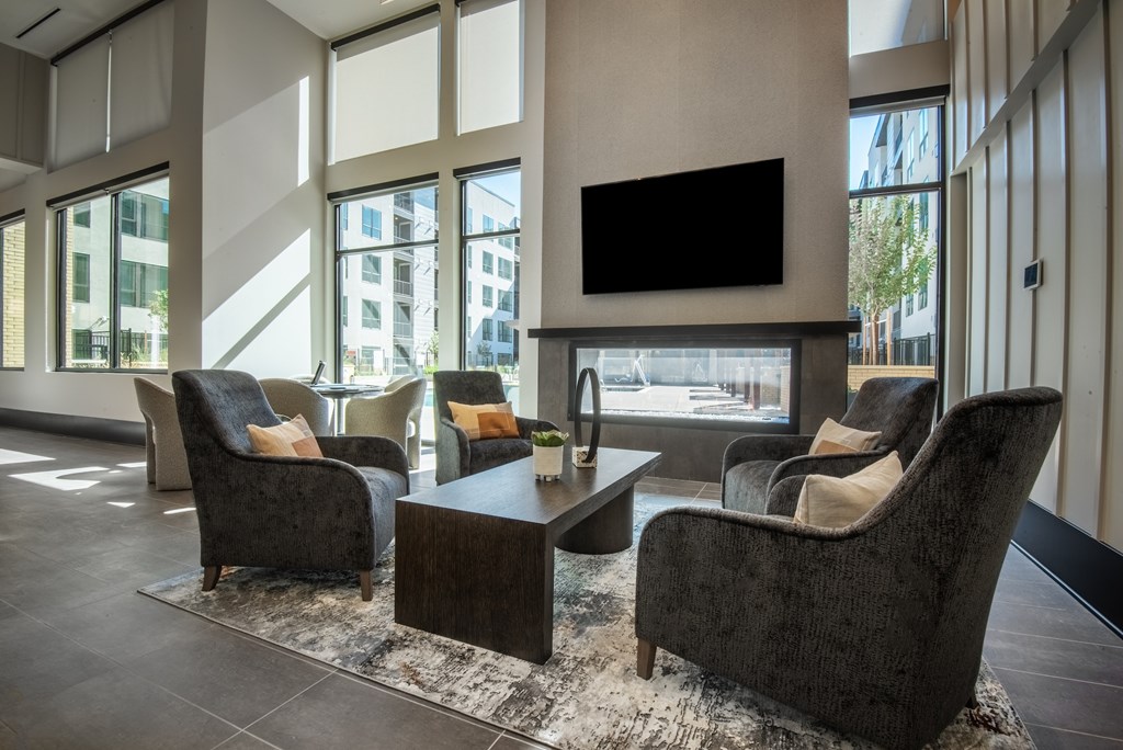 A living room with a black sofa, two armchairs and a coffee table.