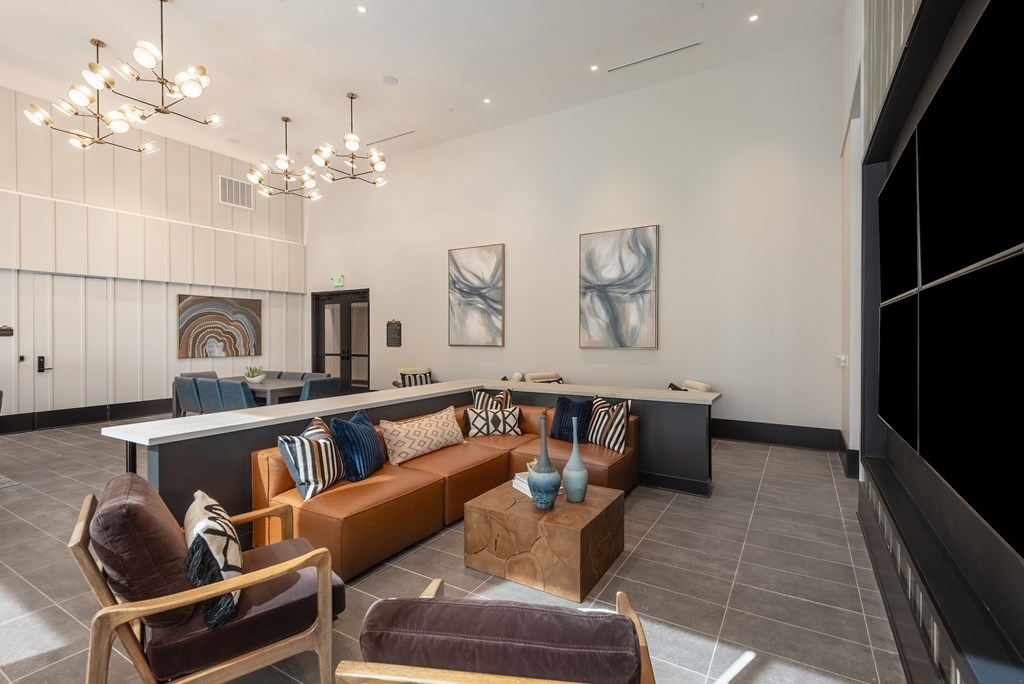 A modern living room with a brown leather chair and a brown leather couch.