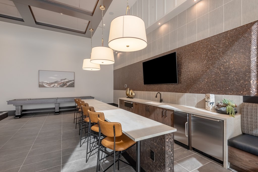 A modern kitchen with a long table and chairs.