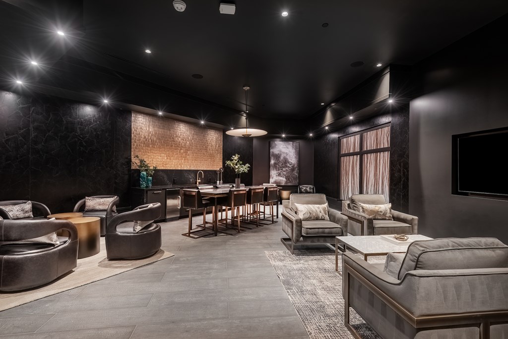 A modern living room with dark furniture and a flat screen TV mounted on the wall.