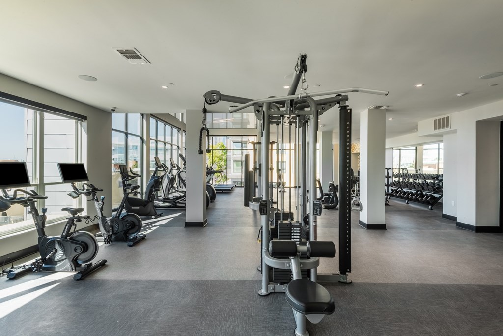 A spacious gym with a variety of equipment including treadmills, stationary bikes, and weight machines.