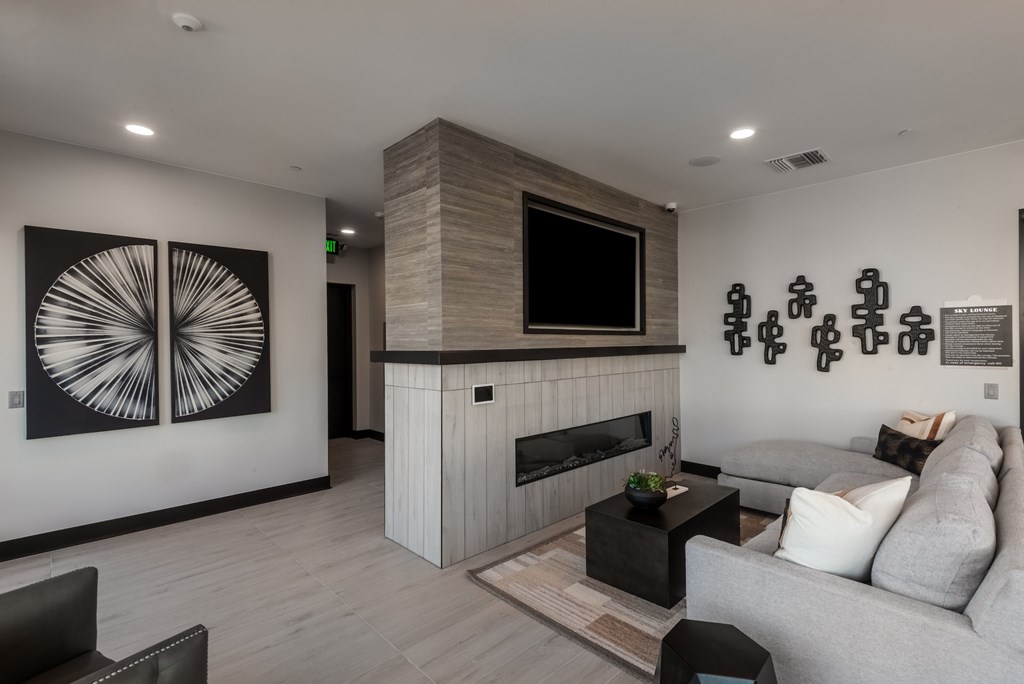 A living room with a grey couch, a fireplace, and a television.