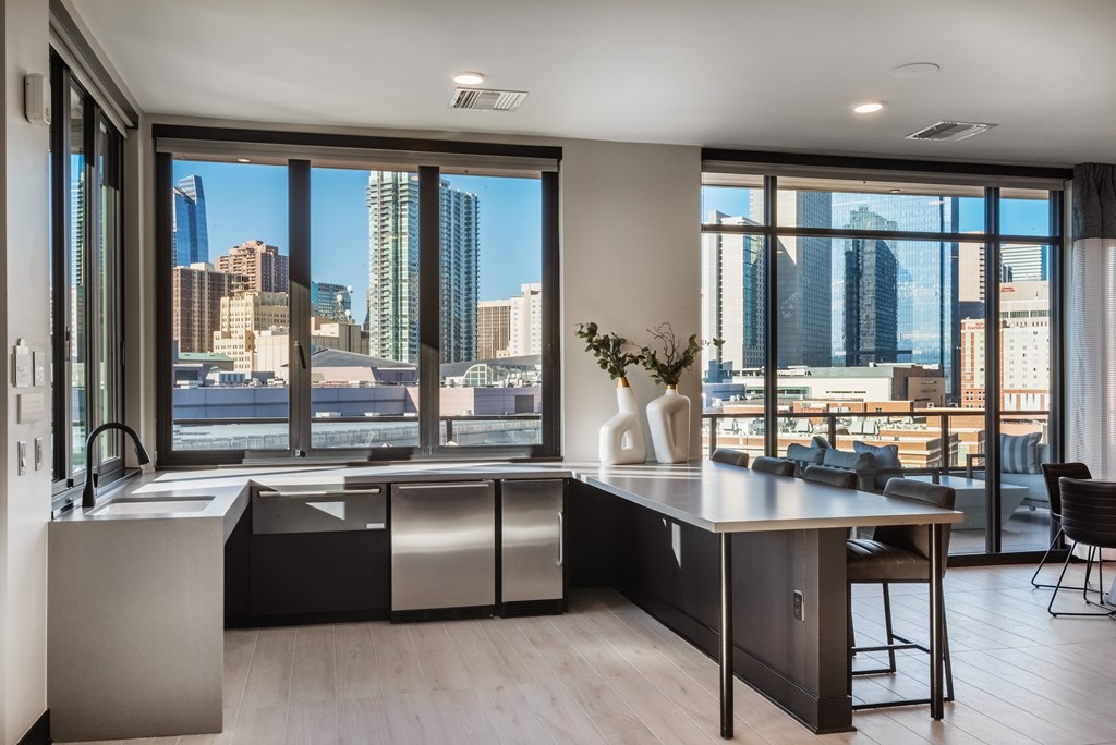 A modern kitchen with a large island and a view of the city.