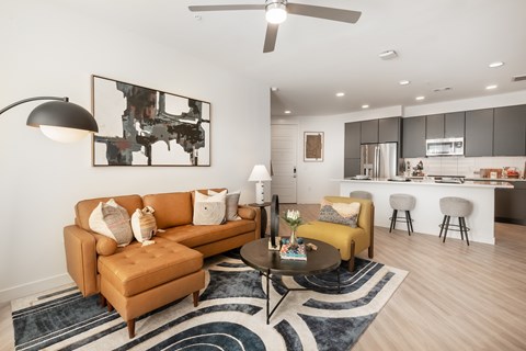 A living room with a brown sofa and a painting on the wall.