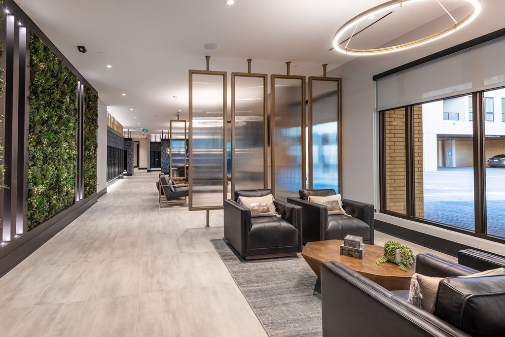 A modern living room with a long couch and a green wall on the side.