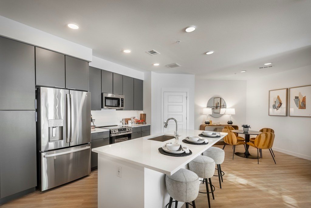 A modern kitchen with a white island and stainless steel appliances.