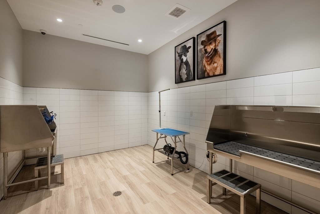 A kitchen with a table and two framed pictures of dogs on the wall.