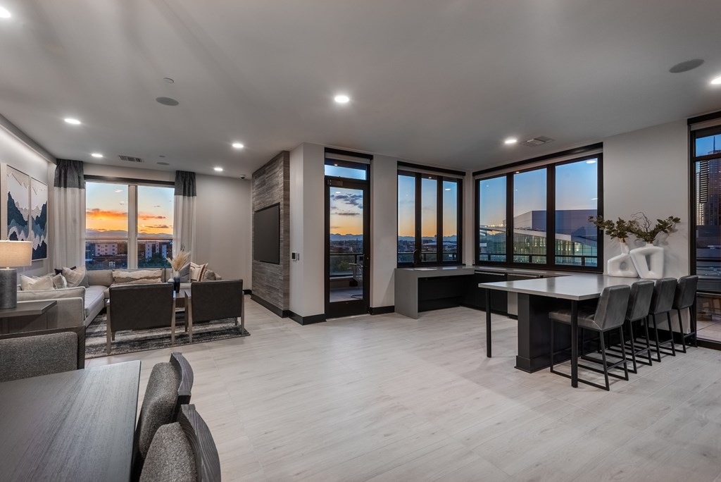 A modern living room with a view of the cityscape at sunset.