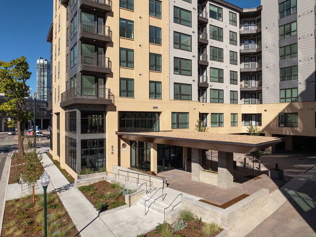 A modern building with a beige facade and large windows.