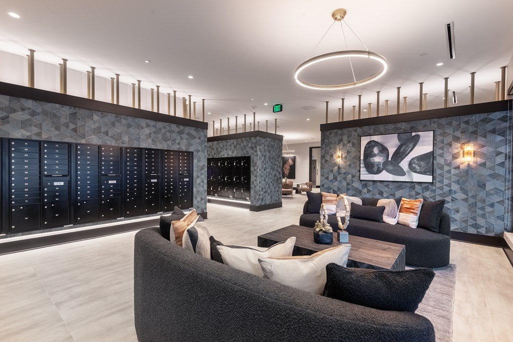 A modern living room with a grey sofa and a large painting on the wall.