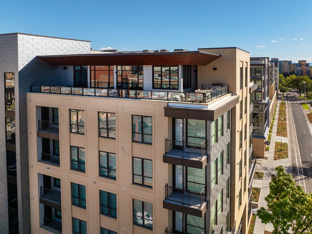 A modern apartment building with balconies and large windows.