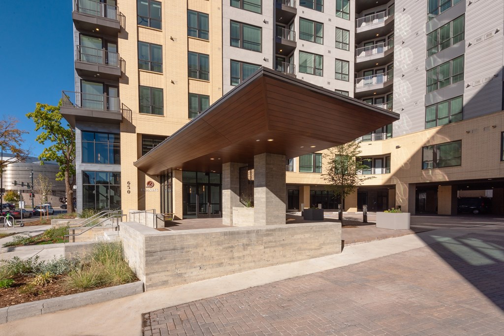 A modern building with a wooden overhang and glass doors.