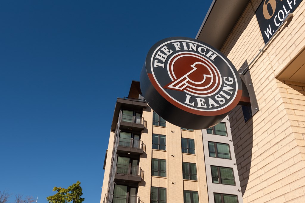 The Finch Leasing sign is hanging on the side of a building.
