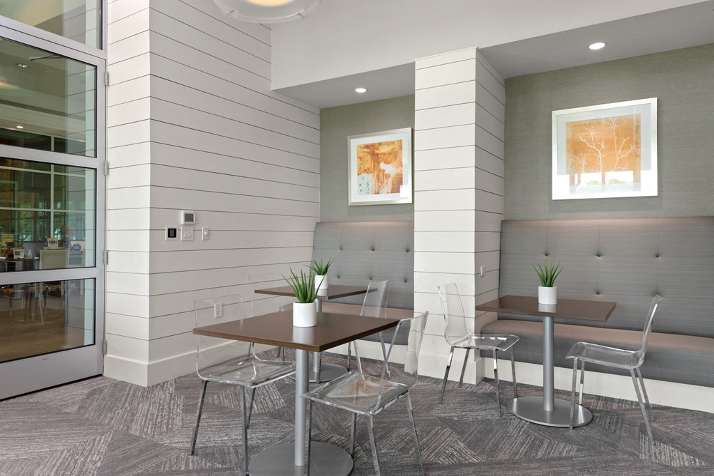 a meeting room with two tables and a bench in front of a glass door