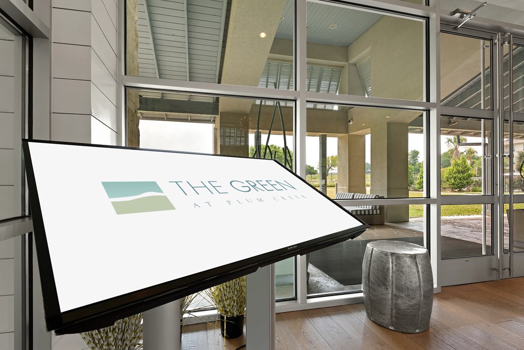 the green at brainerd logo on a table in front of a glass door