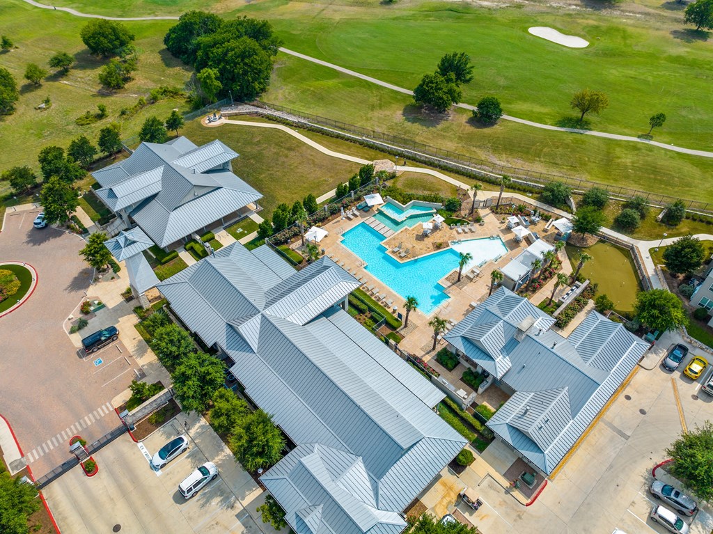 arial view of a resort style pool surrounded by gray roofs