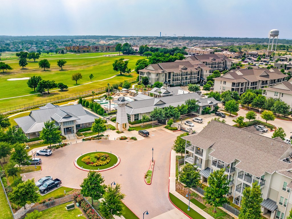 an aerial view of a community with multiple houses and a water tower in the background