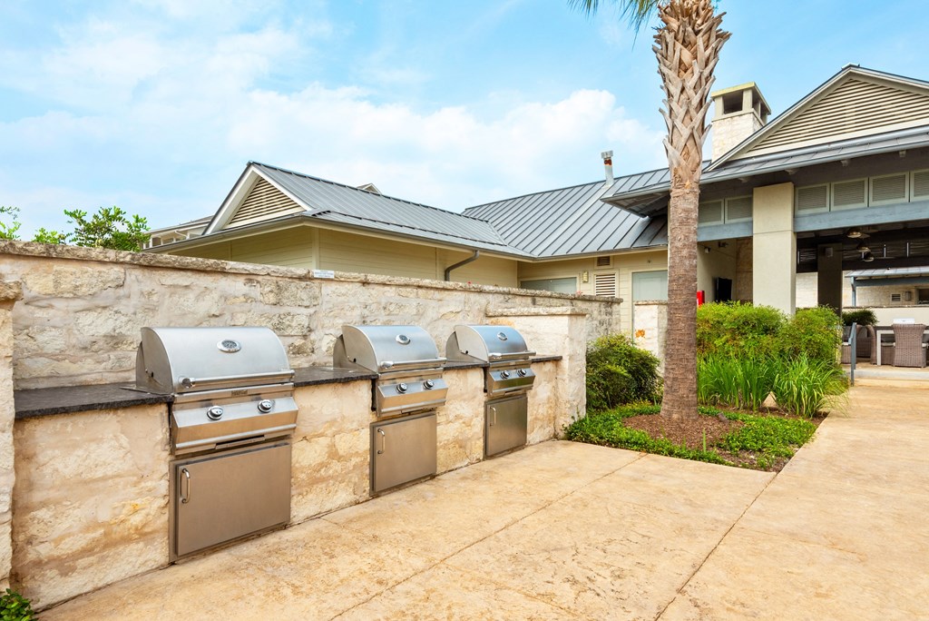 two stainless steel washers and dryers in a stone wall in front of a house