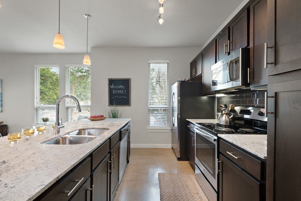 a kitchen with dark cabinets and white countertops
