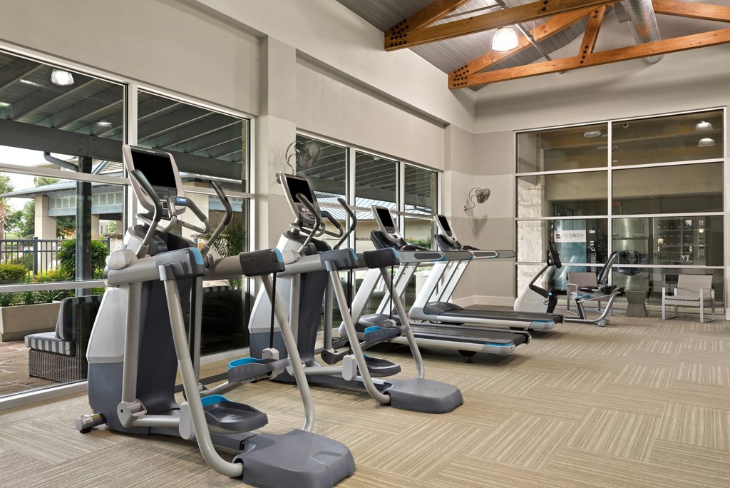 a gym with treadmills and elliptical machines