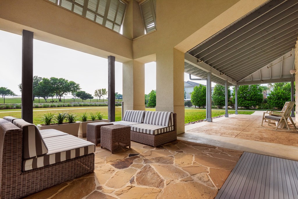 a covered patio with wicker furniture