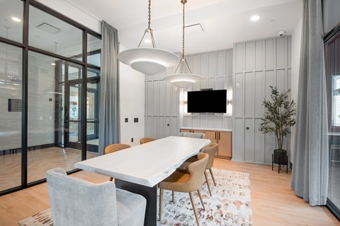 A modern dining room with a large table and chairs.