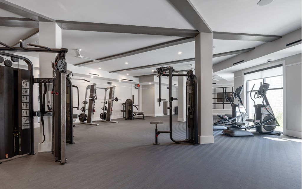 A spacious gym with a variety of equipment including treadmills, weights, and exercise machines.