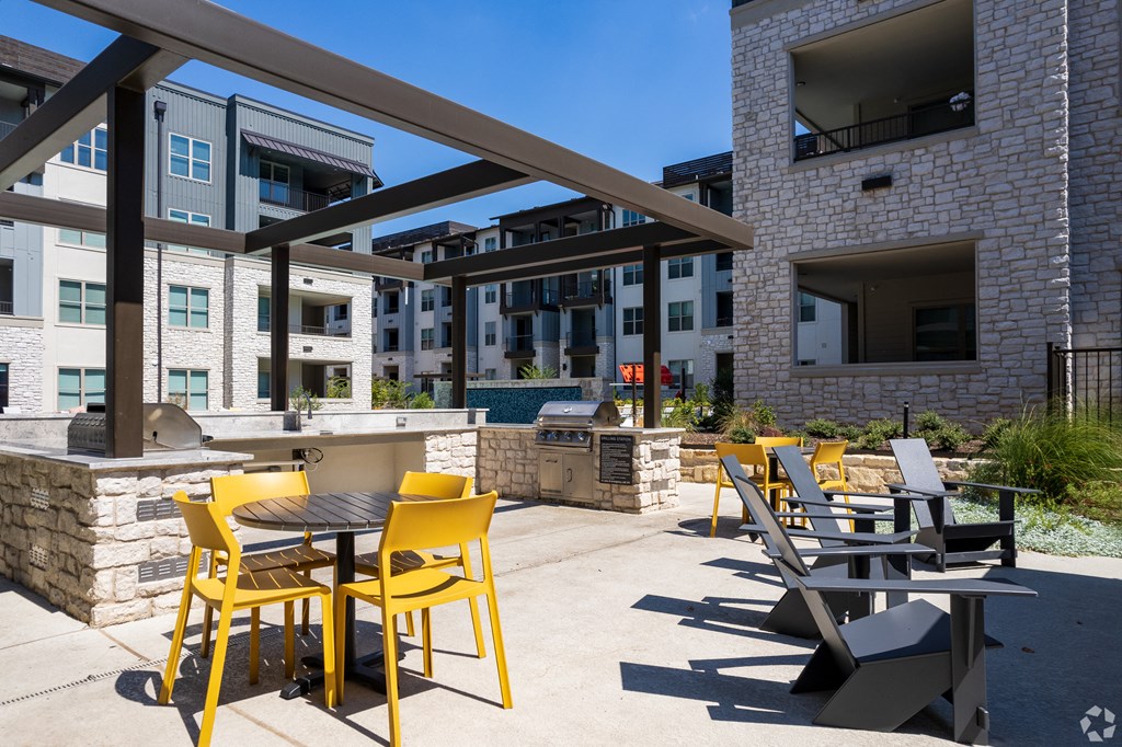 a patio with tables and chairs and a grill at the axis at princeton yards
