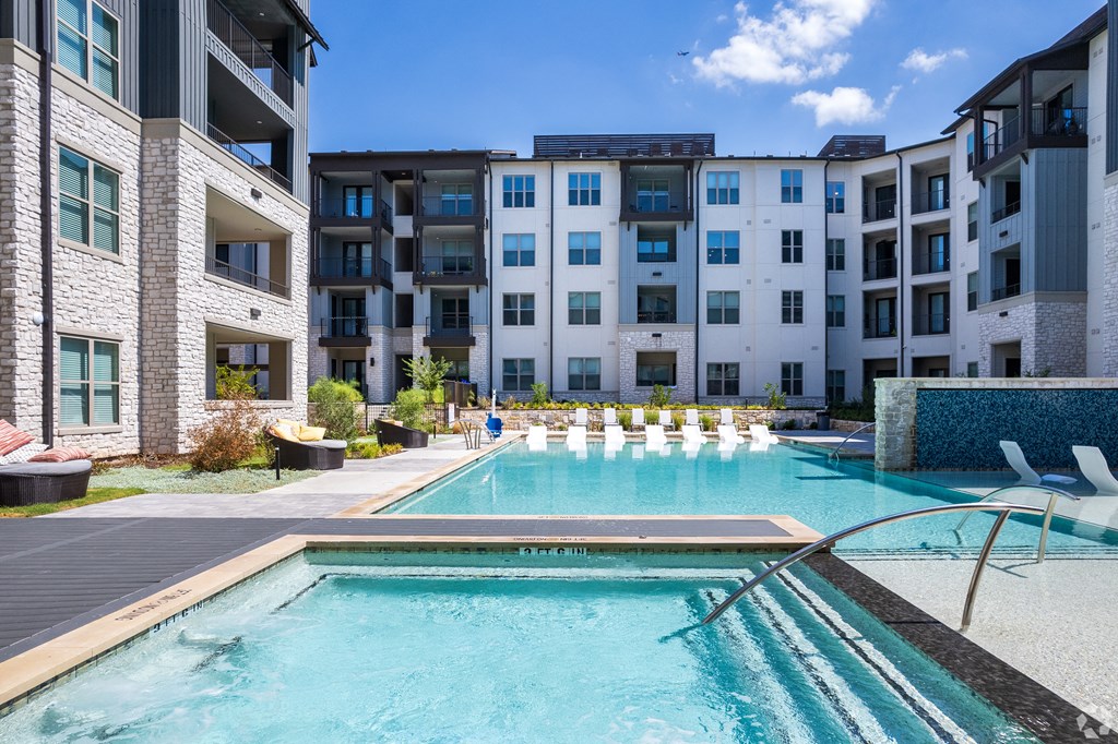 a swimming pool with an apartment building in the background