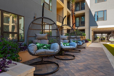 a row of swinging chairs in a courtyard