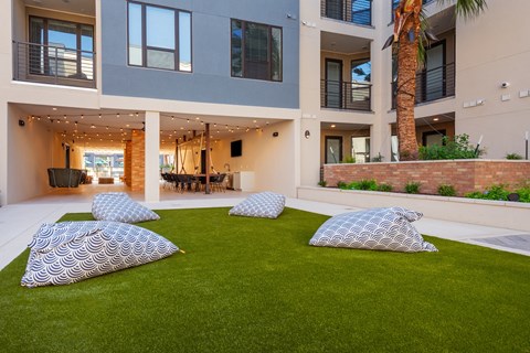 four pillows on a lawn in front of an apartment building