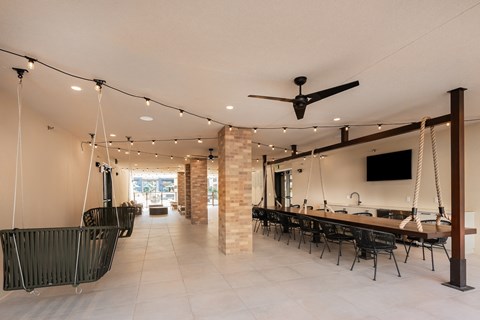 a dining room with a long table and chairs and a ceiling fan