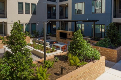 a courtyard with benches and trees in front of a building