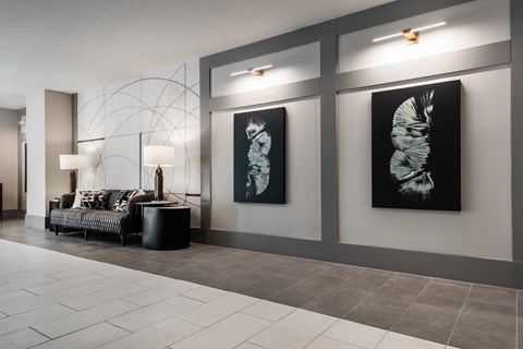 a lobby with a couch and paintings on the wall