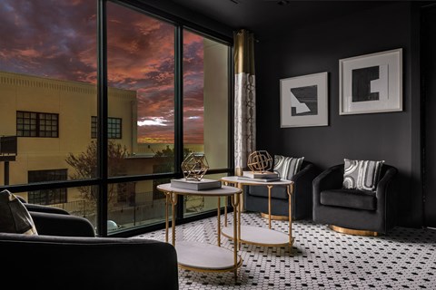 a living room with black walls and a large window